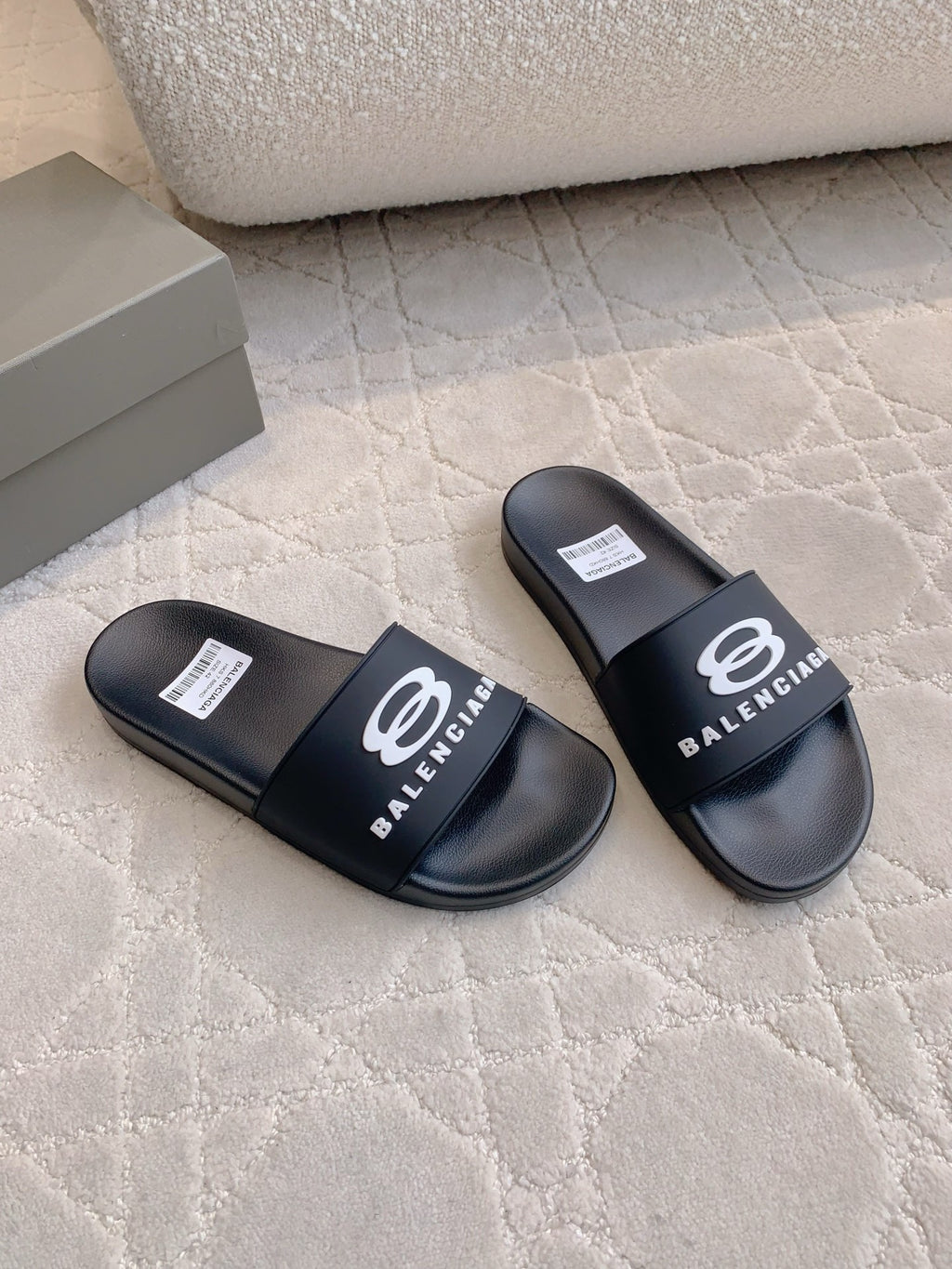 Balenciaga slide sandals in black with logo strap, angled top view