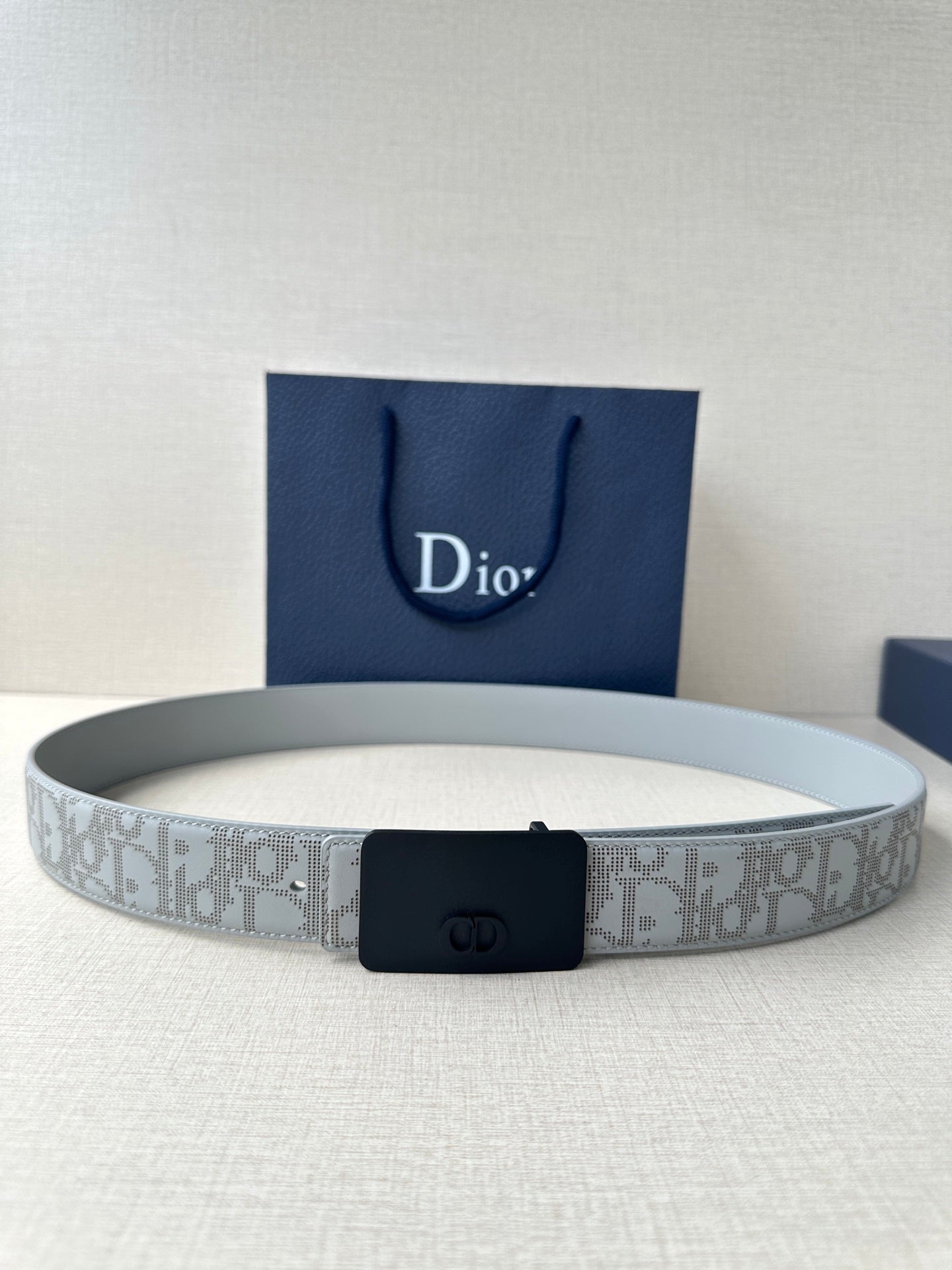 Dior belt with light gray patterned strap and dark navy rectangular buckle