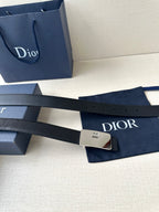 Dior belt laid flat with dark navy strap, silver buckle, and visible belt holes