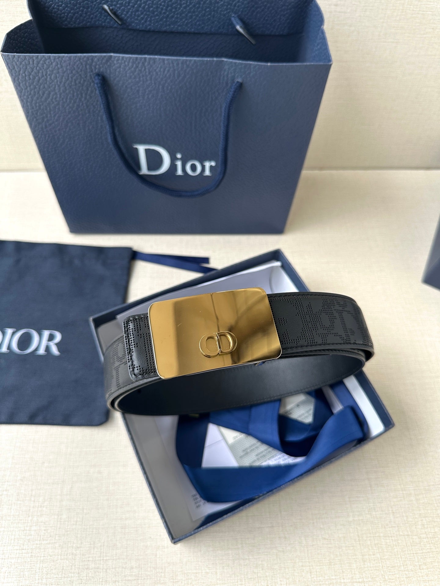 Dior belt with dark navy strap and gold-toned buckle, shown with box and insert