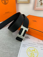 Black Hermes belt with wide strap and silver H buckle on textured leather