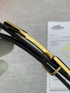 Hermes belt buckle bar and clasp in gold finish, on black leather strap