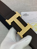 Close-up of gold-tone H buckle on dark leather belt