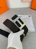 Dark leather belt with silver-tone H buckle, angled view