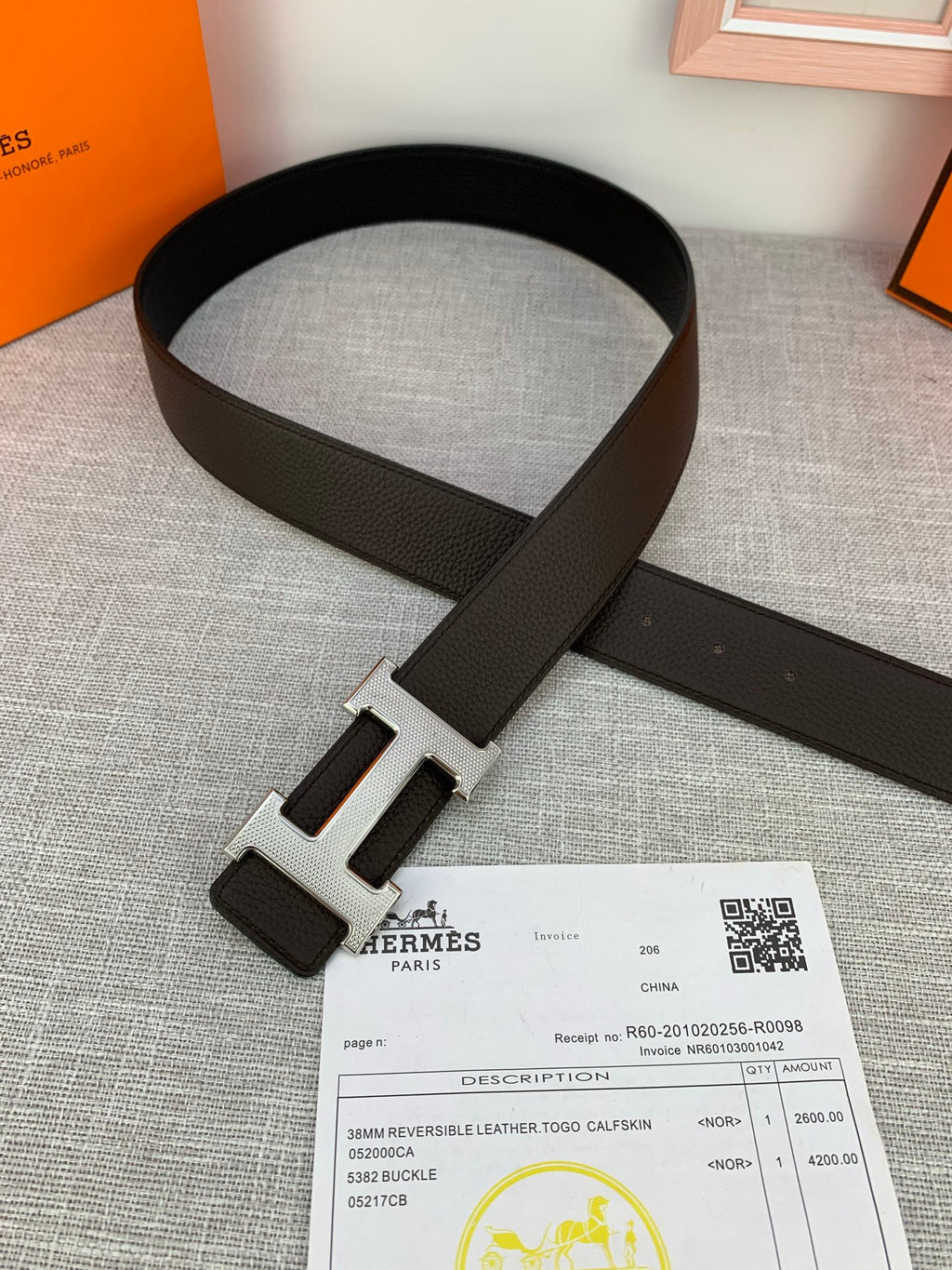 Dark leather belt with silver-tone H buckle and attached keeper