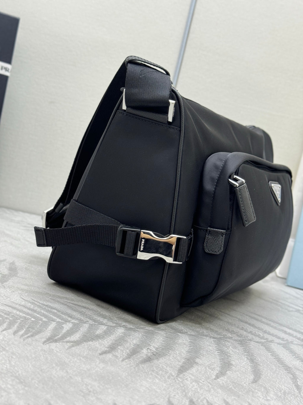 Prada dark messenger bag with adjustable shoulder strap and front flap