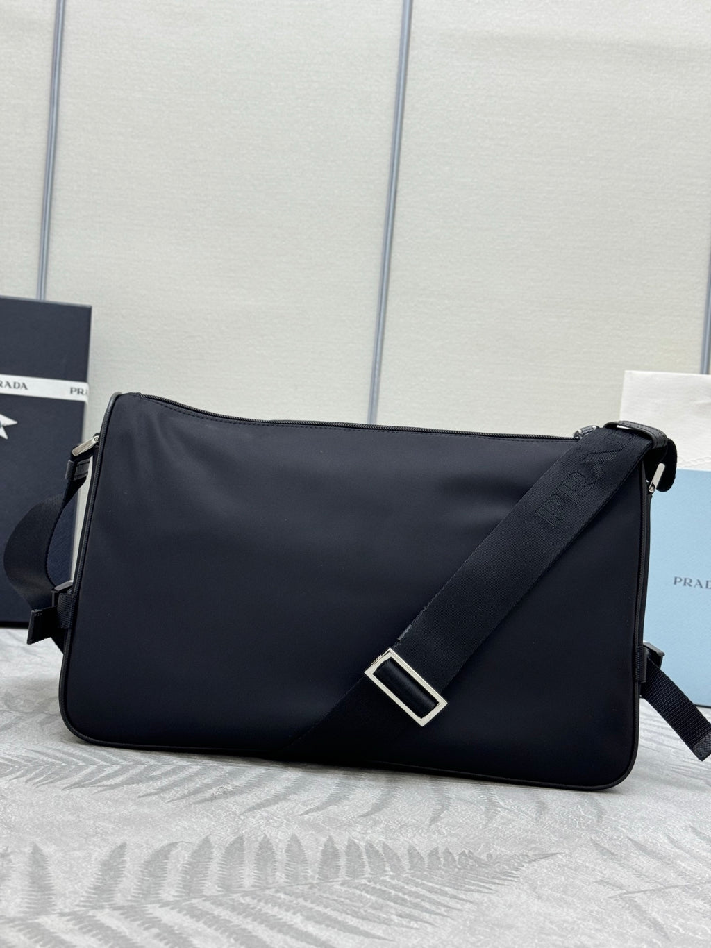 Prada dark shoulder bag with flap, silver turn-lock detail, and strap