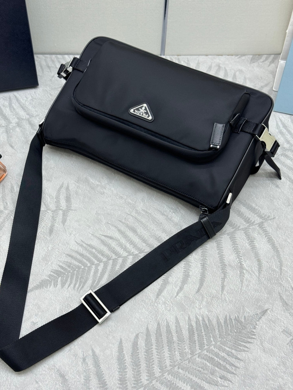 Prada dark flap messenger bag with silver-tone buckle and long strap