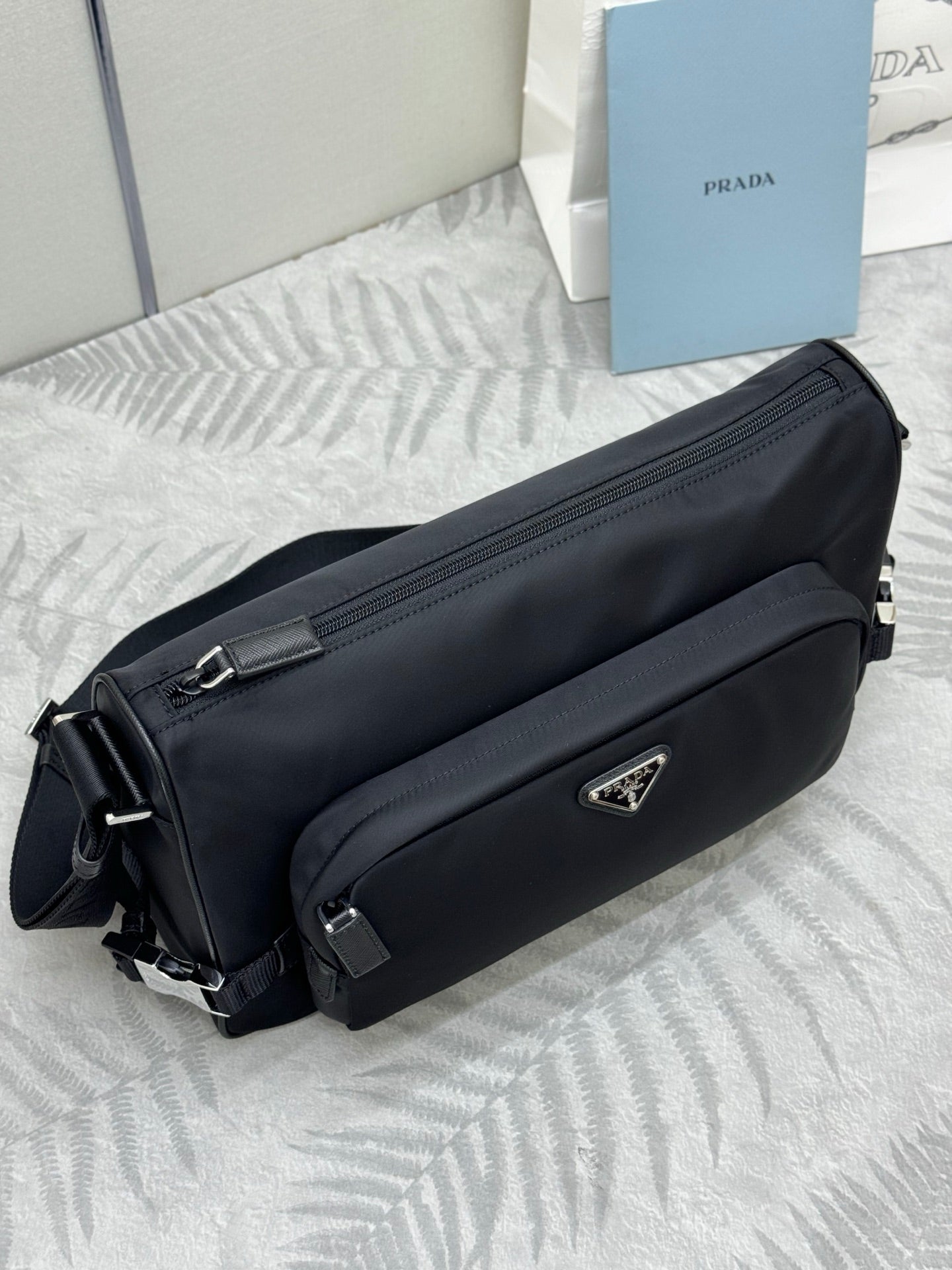 Prada dark shoulder bag with front logo plate and dual side straps