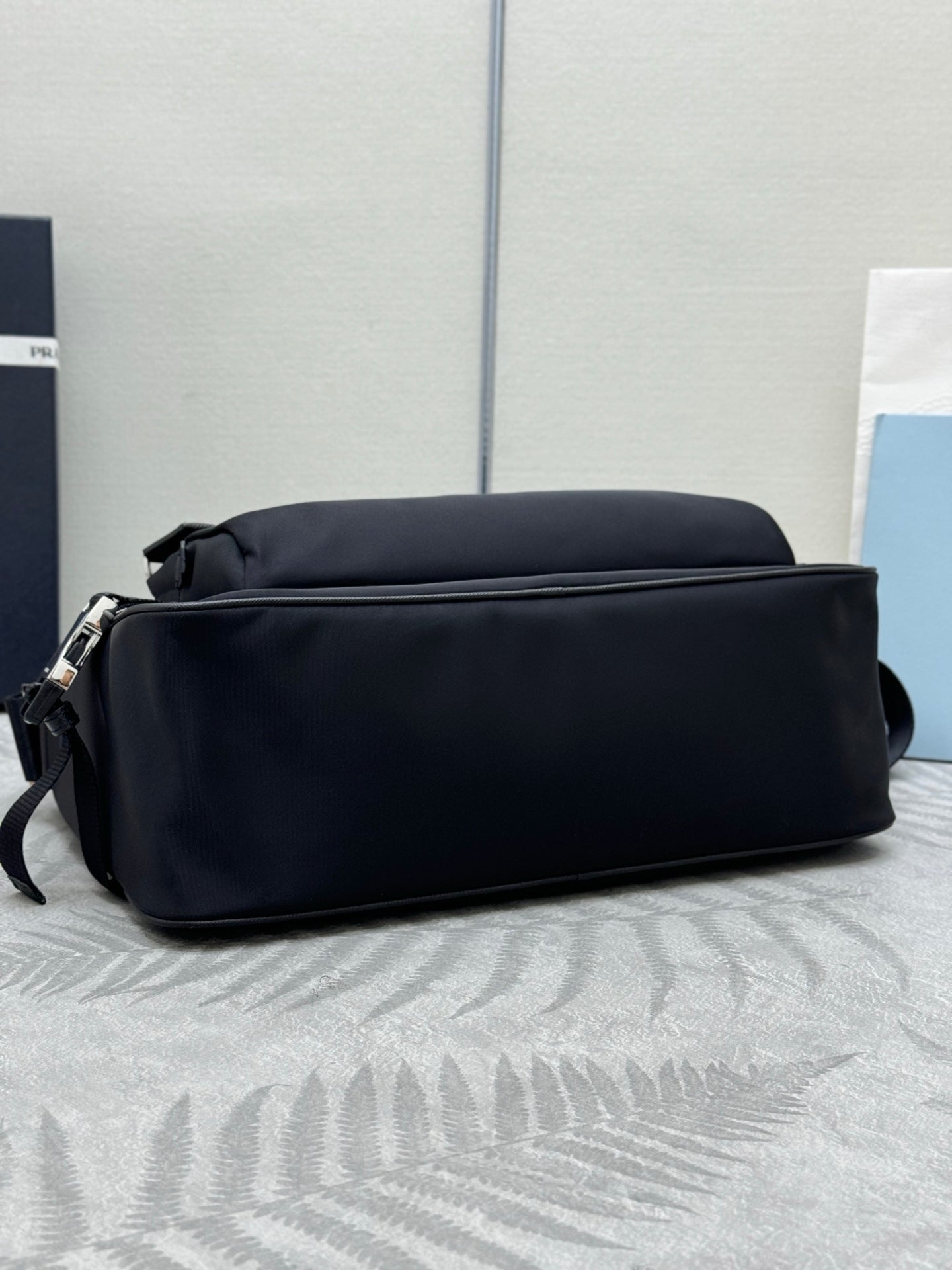 Prada dark crossbody bag with rounded back profile and strap loops