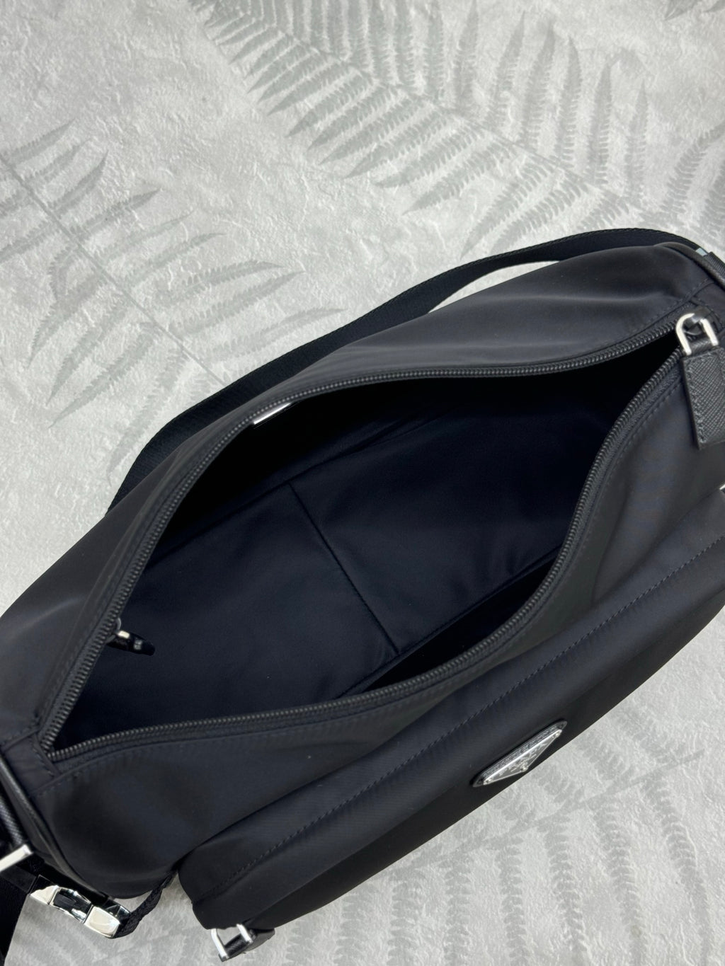 Prada dark crossbody bag interior view with zipper opening and lining