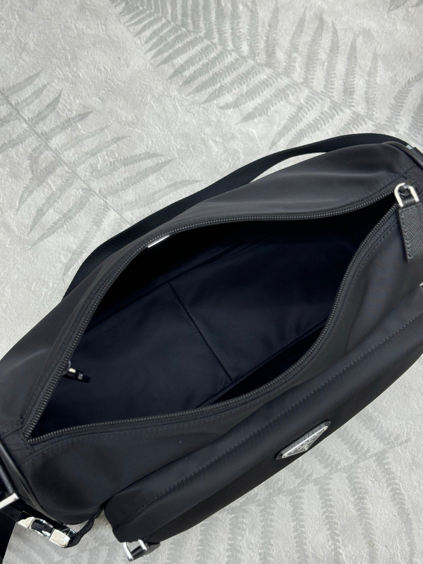 Prada dark crossbody bag interior view with zipper opening and lining