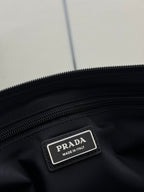 Prada dark bag label patch reading “PRADA” and “MADE IN ITALY”