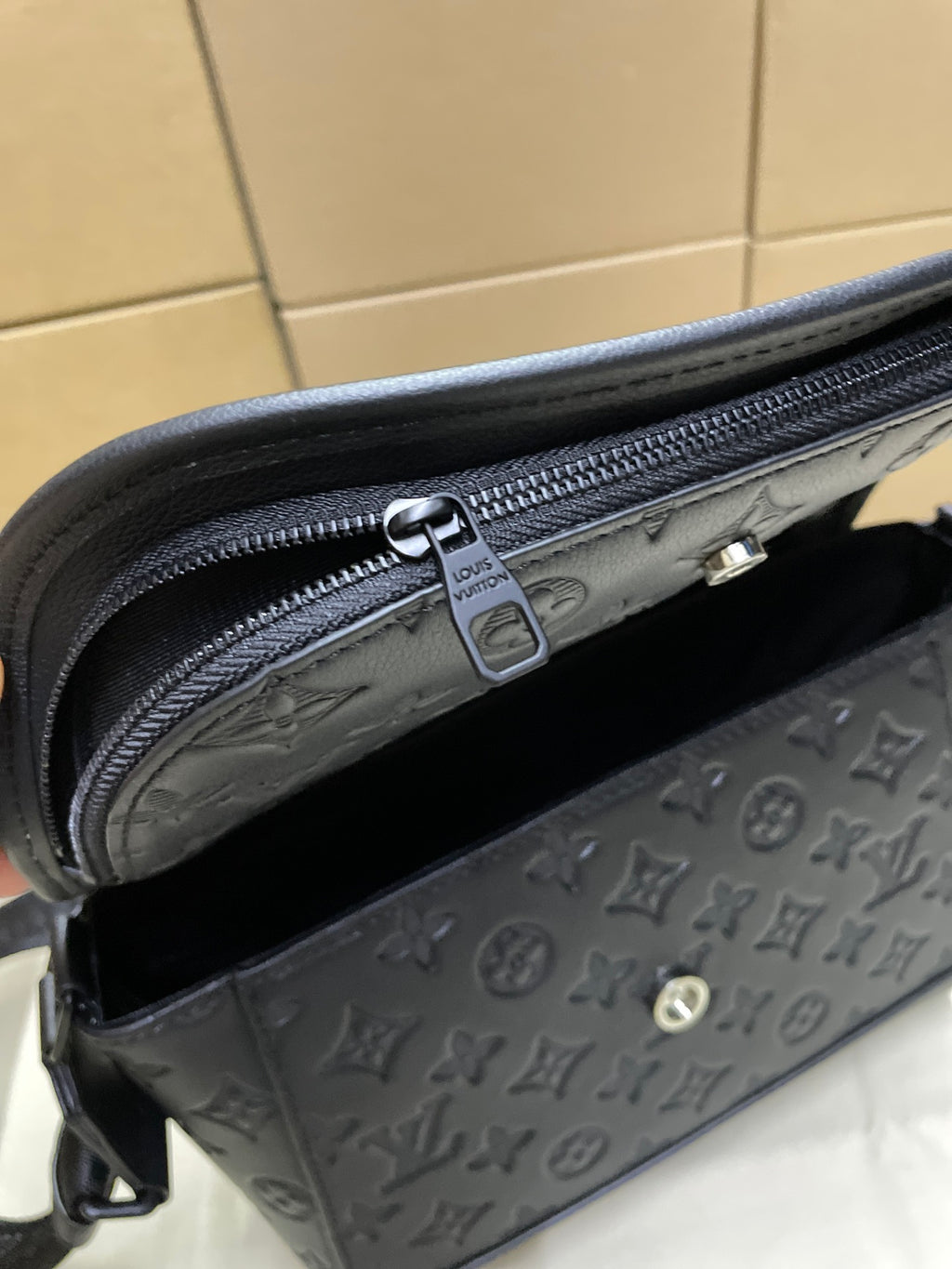 Louis Vuitton dark monogram crossbody bag interior view with zipper and logo patch