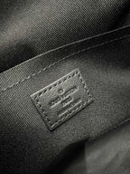 Louis Vuitton dark crossbody bag close-up of stitched logo leather label