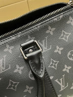 Louis Vuitton monogram bag close-up of zipper pull and metal hardware, dark gray