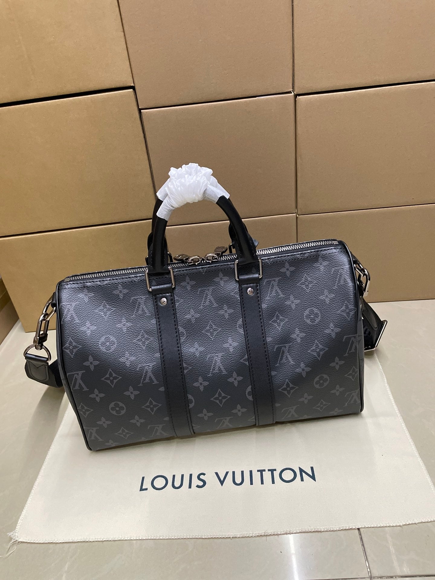 Monogram duffel bag front view with top handles, zipper top, and crossbody strap