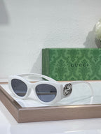 Gucci sunglasses with white frame and dark lenses, metal logo hinge detail
