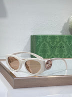 Gucci sunglasses with white frame and tan lenses, metal logo hinge