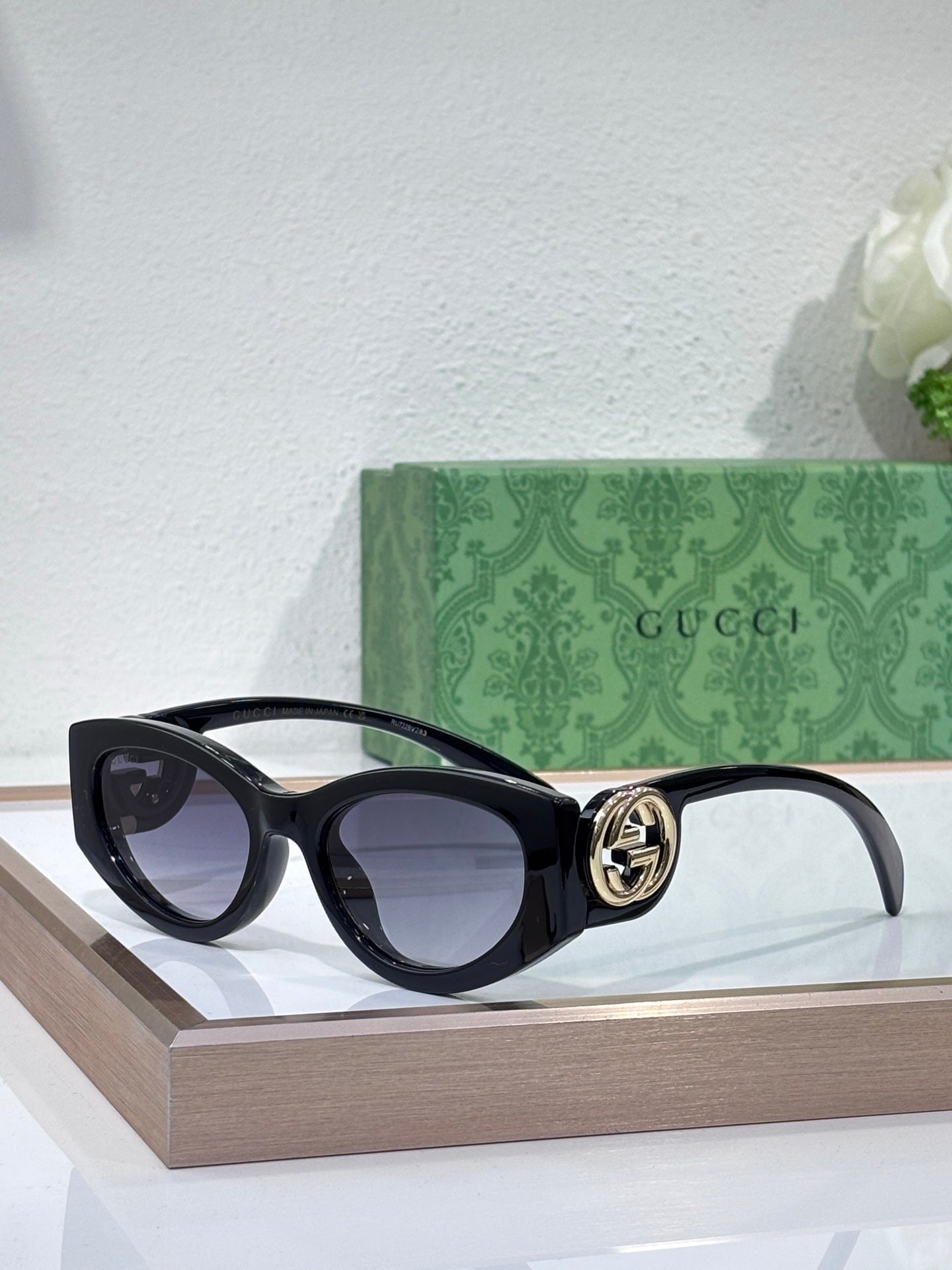Gucci sunglasses with black frame and dark lenses, logo detail at the hinge