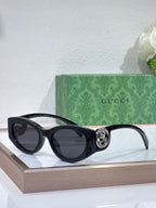 Gucci sunglasses with black frame and dark lenses on a display stand