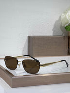 Metal-framed oval sunglasses with brown lenses and textured gold temples