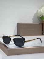 Metal-framed oval sunglasses with dark lenses and textured gold temple arms
