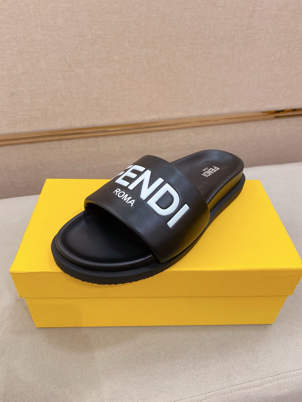 Black slide sandals with wide strap and FENDI logo on the upper.
