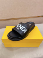 Black slide sandals with wide strap and FENDI logo on the upper.