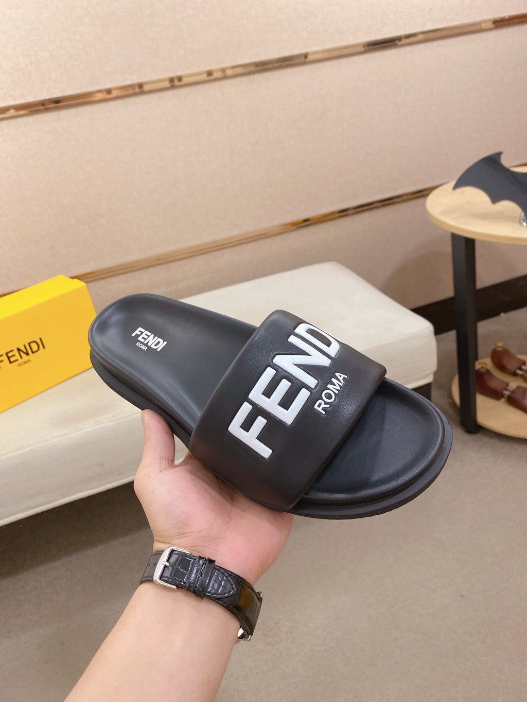 Black slide sandal with wide strap featuring FENDI ROMA text on the upper.