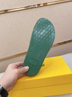 Green slide sandal outsole with textured pattern; underside held up in hand.