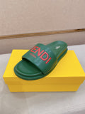 Green slide sandals with wide strap and large red FENDI logo on the footbed.