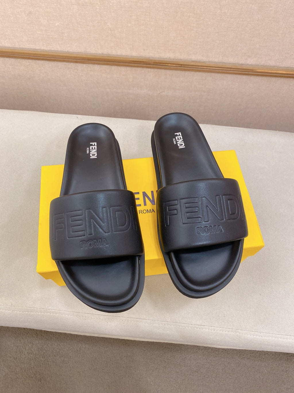 Fendi slide sandals in dark blue, front pair on yellow box