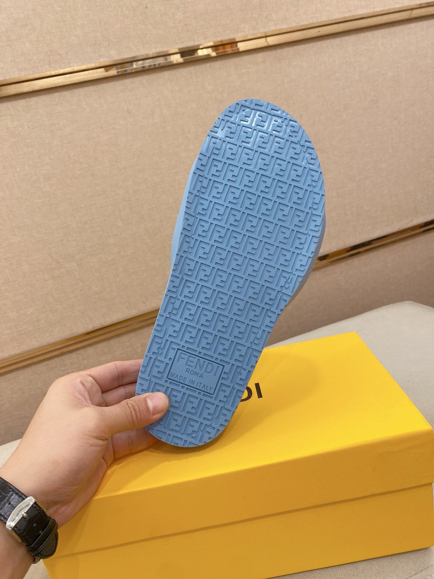 Light blue slide sandal outsole with repeating embossed Fendi-pattern texture