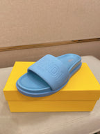 Light blue slide sandals with embossed logo strap and molded footbed