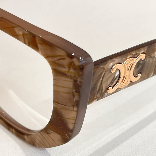 Brown translucent eyeglass frame with gold logo detail on the temple