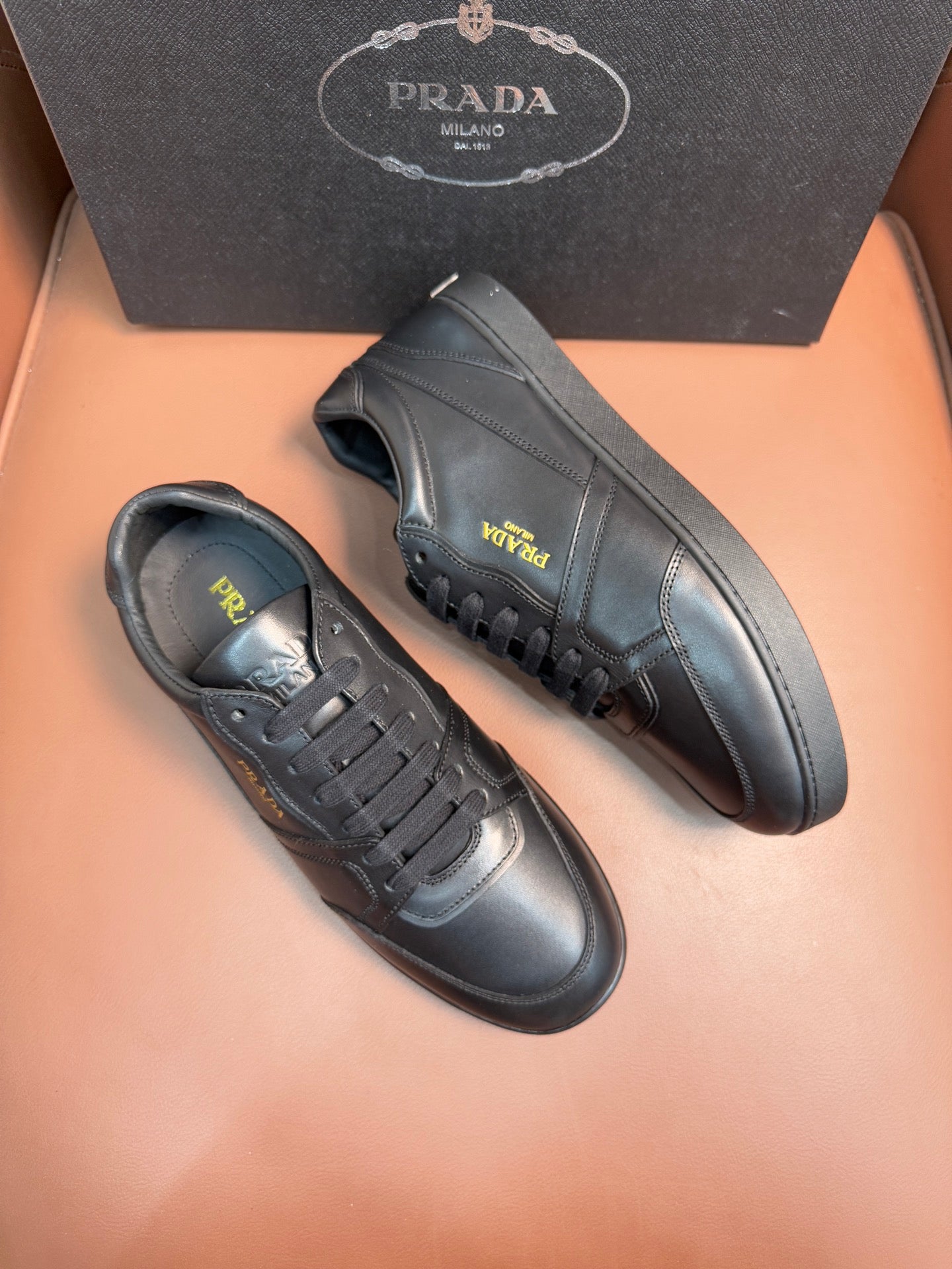 Dark leather lace-up sneakers with side logo detail and chunky sole.