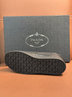 Sneaker outsole with textured rubber tread and small Prada mark.