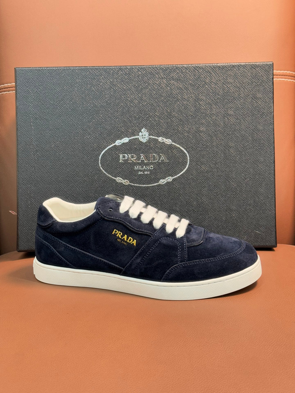 Prada unisex sneakers, navy suede with gold-toned logo patch and white laces