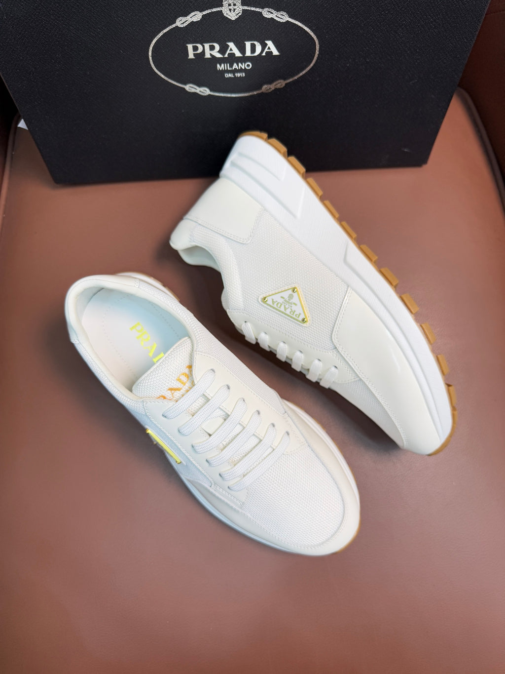 Prada unisex white sneakers, one side angle with triangle logo and gum sole