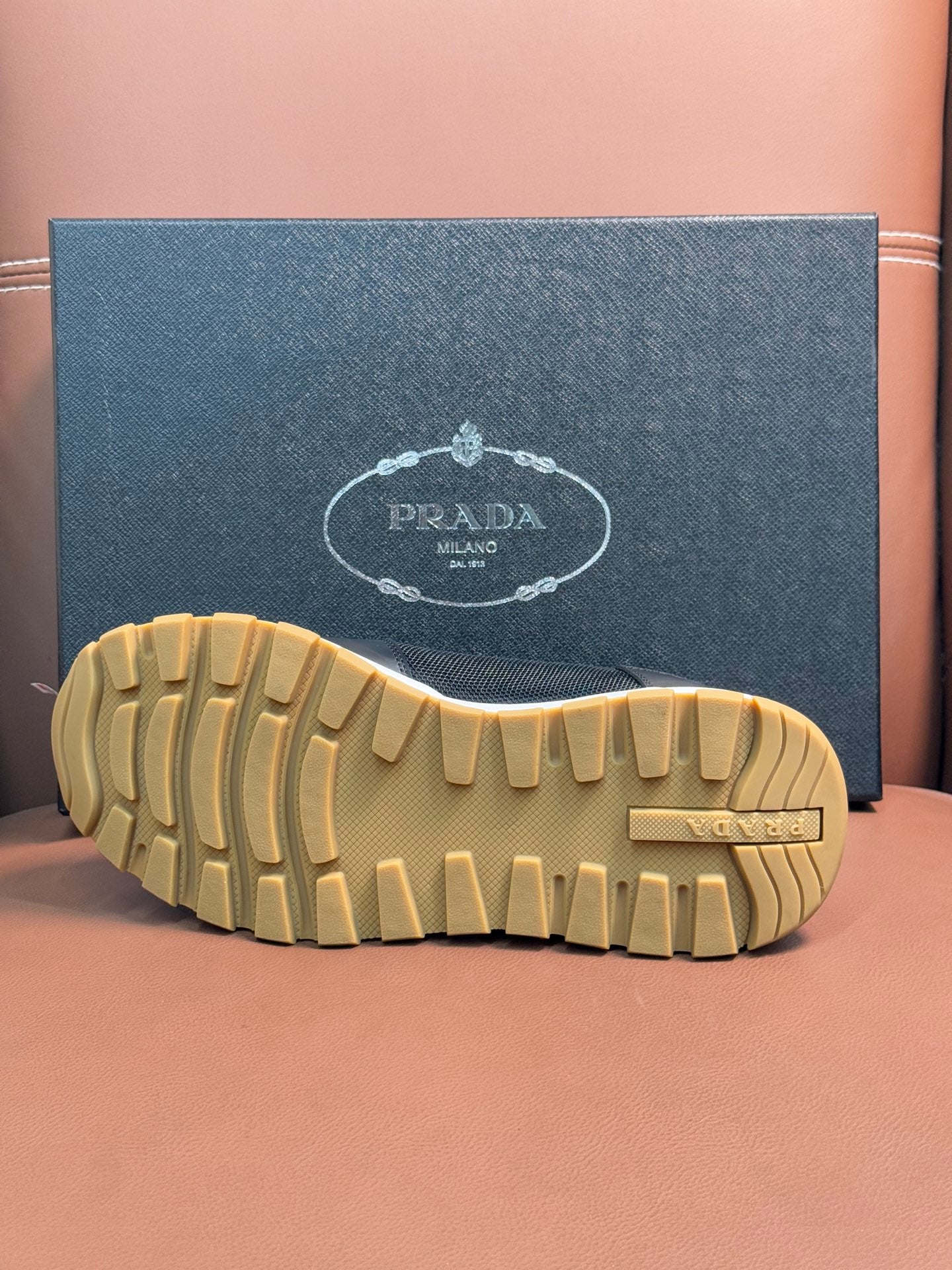 Prada unisex sneaker outsole, beige ribbed tread and raised heel section.