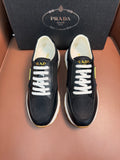 Prada unisex sneakers in dark blue-black with white laces and thick white sole.
