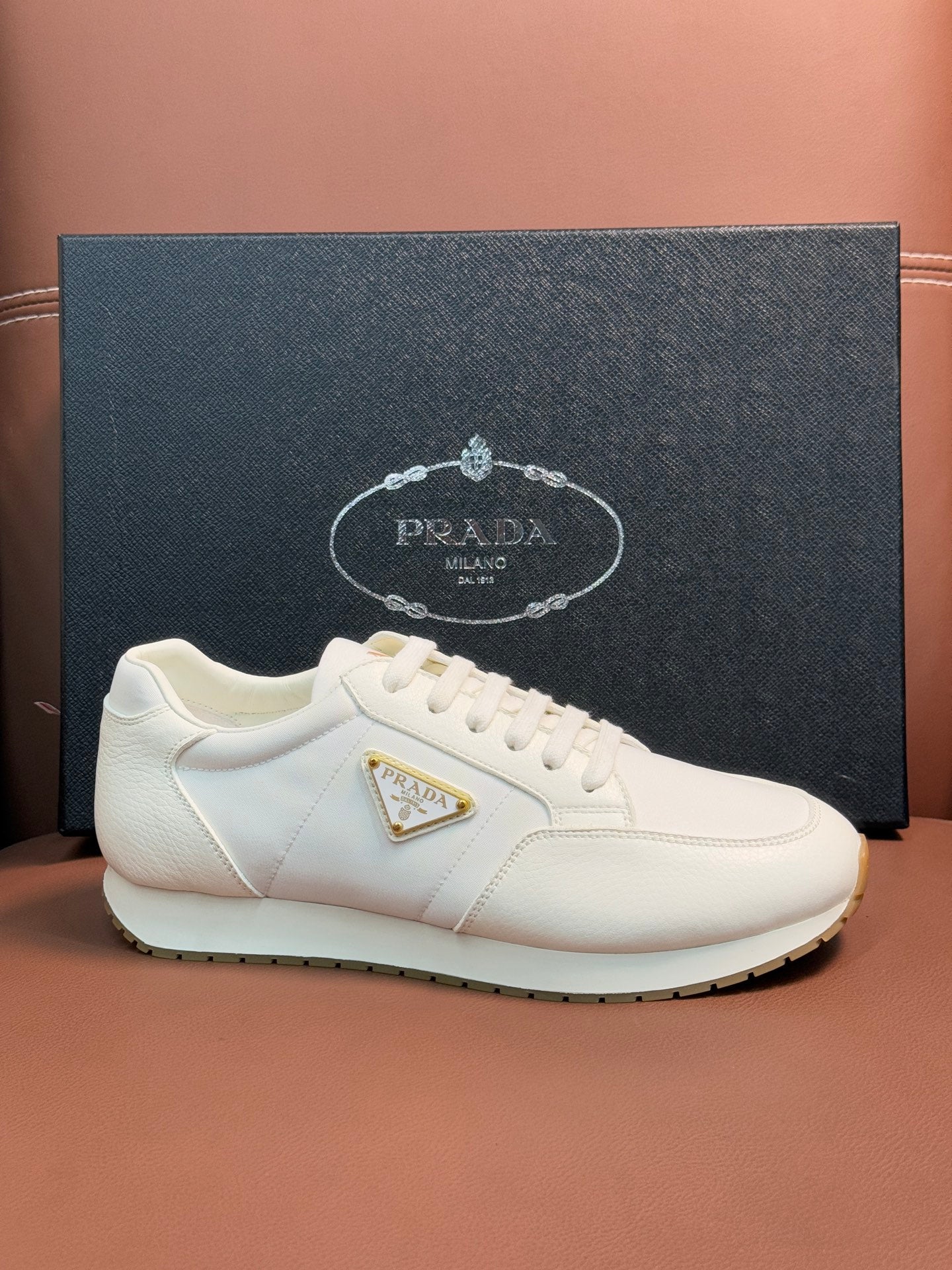 Prada unisex sneakers, white low-top lace-ups with gold triangular logo on quarter
