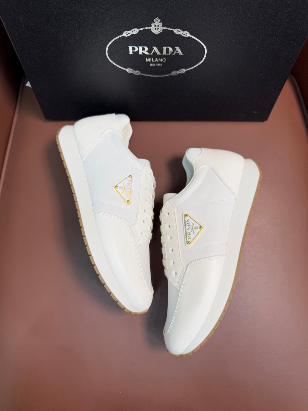 Prada unisex sneakers, white uppers with gold triangular logo and brown outsole