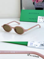 Bottega Veneta oval sunglasses with pink frames and brown lenses, gold temple accent.