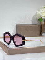Sunglasses, dark purple oversized square frames with light pink tinted lenses and gold temples