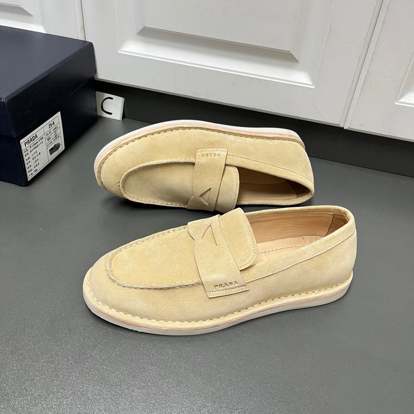 Beige Prada unisex loafers, side view with top strap and stitched sole