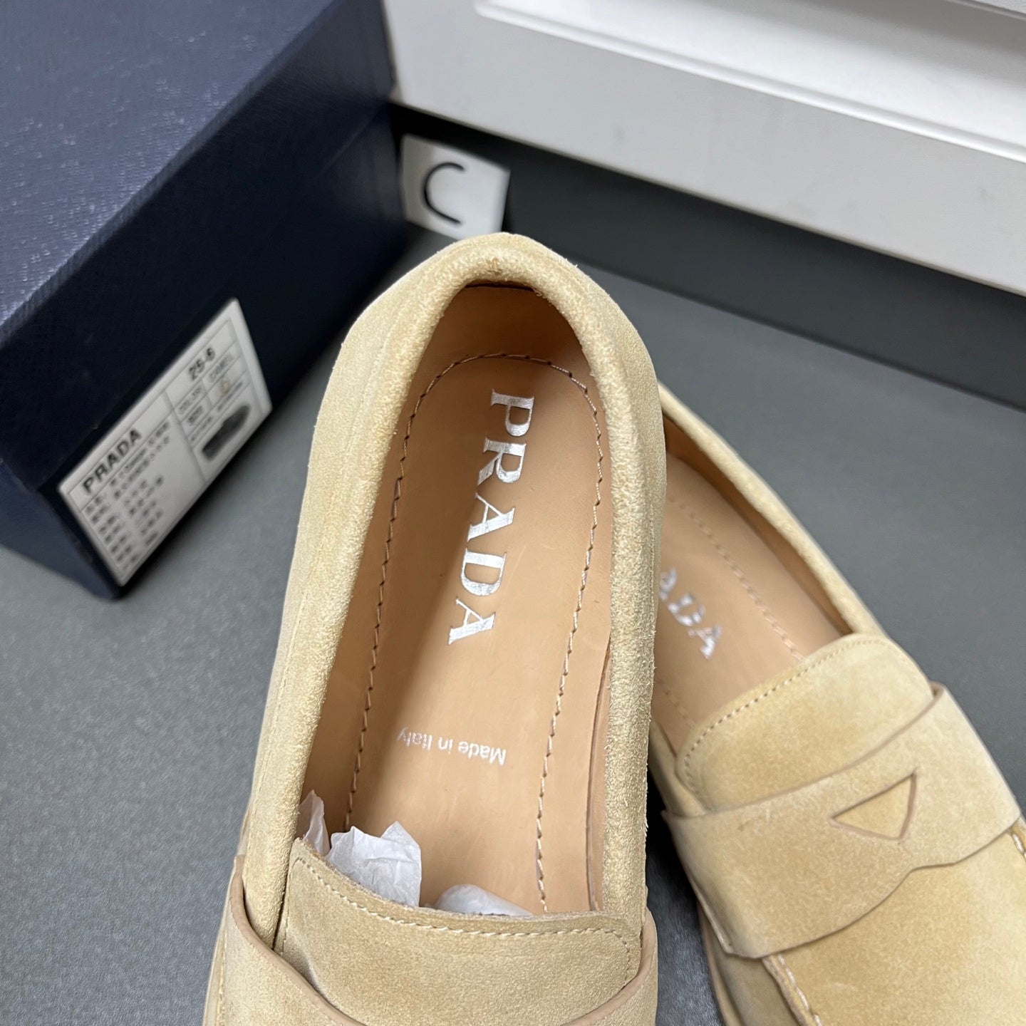 Beige Prada unisex loafer, close-up of interior and PRADA logo on insole