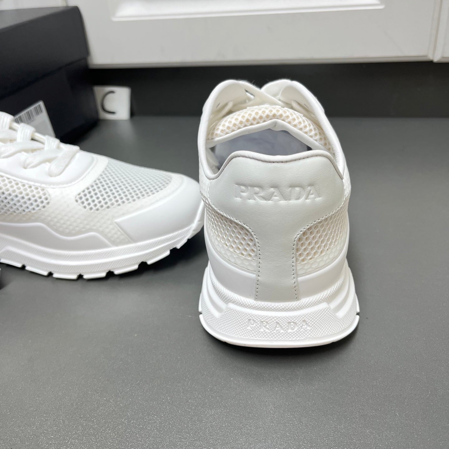 White Prada sneakers heel view with cushioned back and mesh side panels