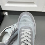 Prada unisex sneakers close-up of toe and lace-up, light gray mesh texture